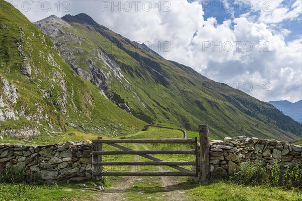 Natural stone wall with wooden gates