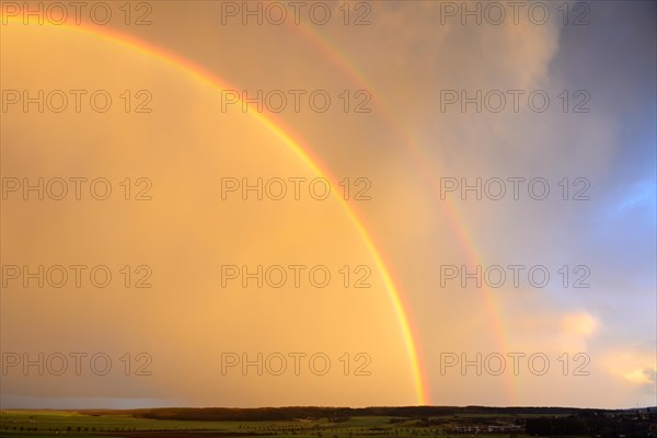 Double rainbow over agricultural landscape