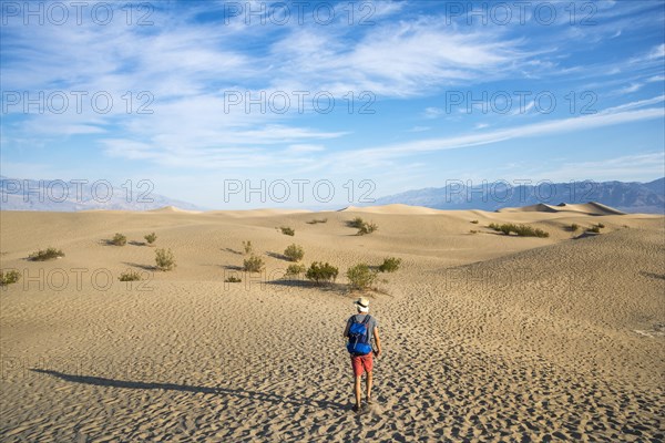 Young man hiking on sand dunes