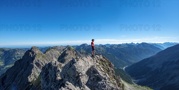 Hiker stands on rocks looking into the distance