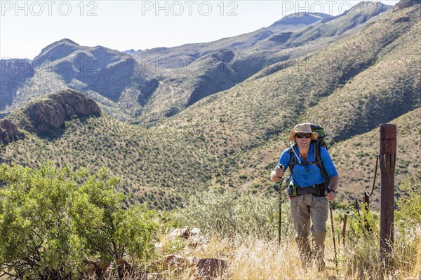 Hiker with backpack and sticks