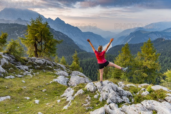 Hiker stretches arms into the air