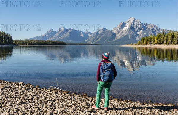 Young woman with rucksack standing on the shore