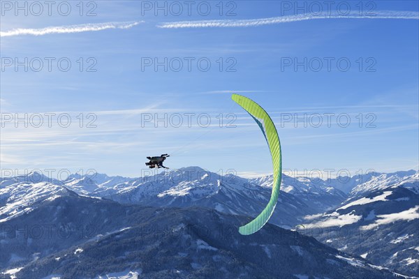 Paraglider flies from the Hohe Salve into the valley of Hopfgarten