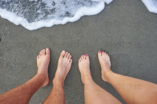 Two feet standing at the surf from the sea