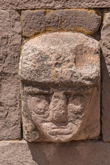Stone head in wall of Kalasasaya Temple (place of standing stones) with monoliths from the pre-Inca period