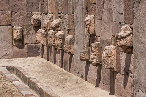 Stone heads in wall of Kalasasaya temple (place of standing stones) with monoliths from pre-Inca period