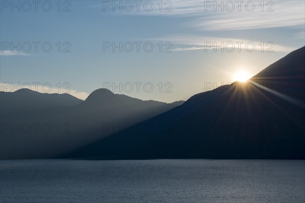 Evening sun shines over mountain silhouette