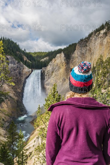 Young woman looking at a waterfall