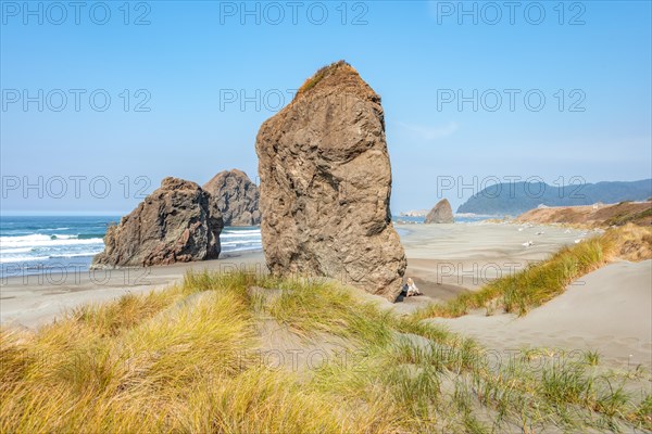 View over sandy beach with large monolithic rocks