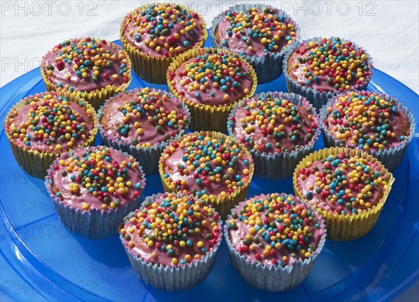 Cupcakes with colorful sugar pearls on blue plate