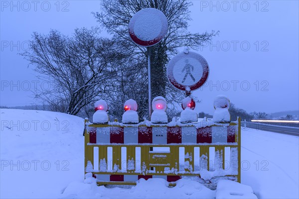 Illuminated snow barrier in winter at dusk