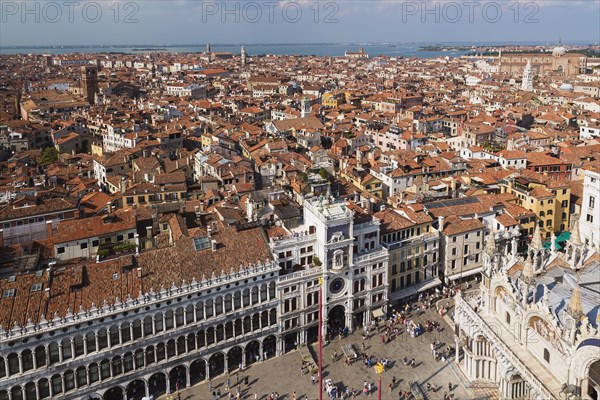 Procuratie Vecchie building with St Mark's clock tower and St Mark's Basilica and old architectural style residential buildings with terracotta rooftops taken from the Campanile bell tower in St Mark'...