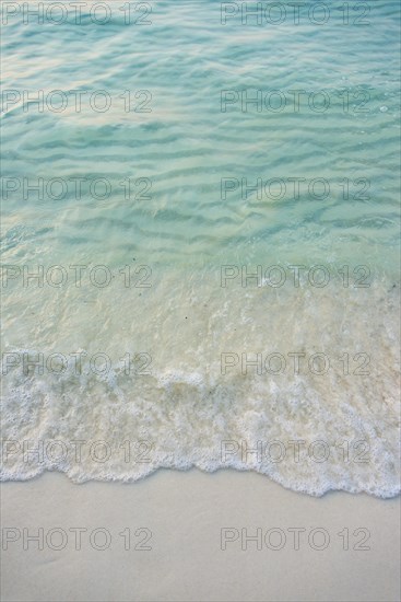 Waves on sandy beach with turquoise water at Koh Tui Beach