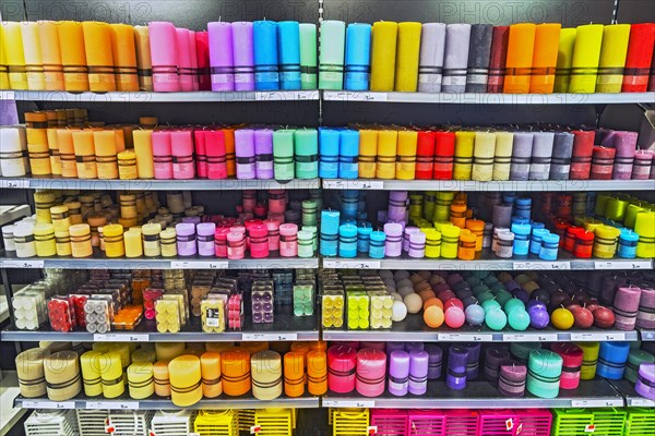 Shelves with different coloured candles in the supermarket