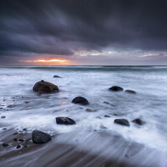 Stormy sea with dark clouds at sunset on the beach of the Baltic Sea