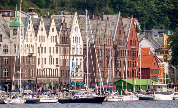 Sailing ships in front of row of houses