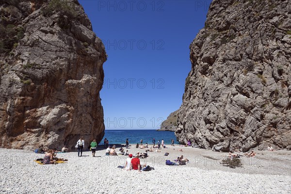 People sunbathe on the beach in the gorge Torrent de Pareis