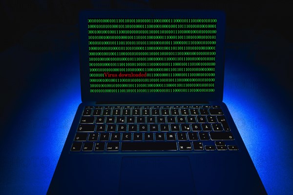 Laptop with binary numbers on screen. Symbol image malware