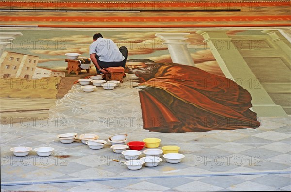 Artist creating image using coloured sand