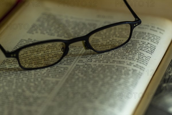 Opened old book with glasses