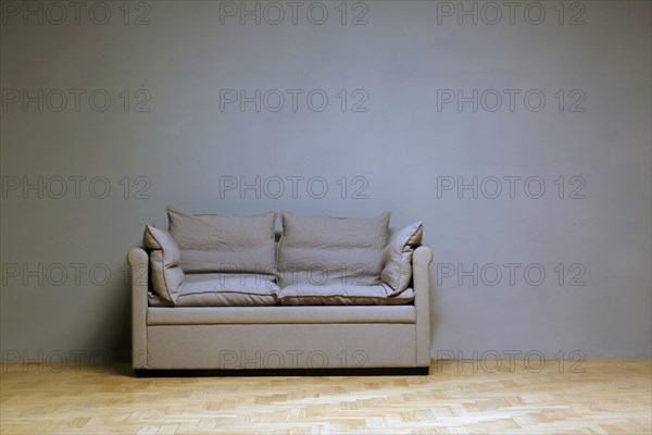 Lonely couch in front of a wall in the room