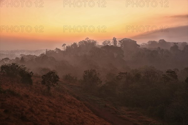 Sunrise with morning haze over wooded hills