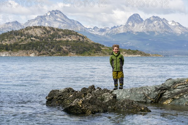 Little boy standing on rocks on the banks of the Beagle Channel
