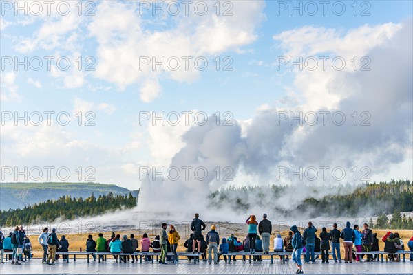 Tourists observe eruption of Old Faithful Geyser