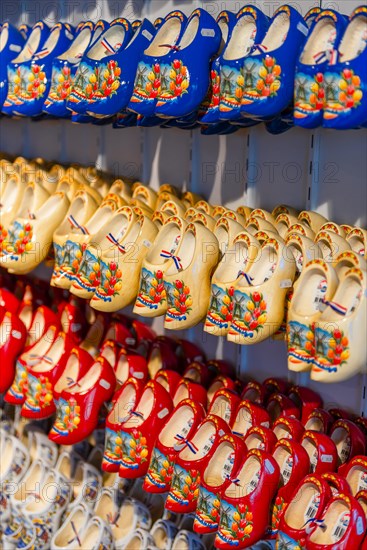 Traditionally colorfully painted Dutch wooden shoes on rack for sale