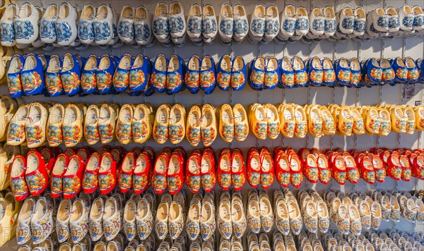 Traditionally colorfully painted Dutch wooden shoes on rack for sale