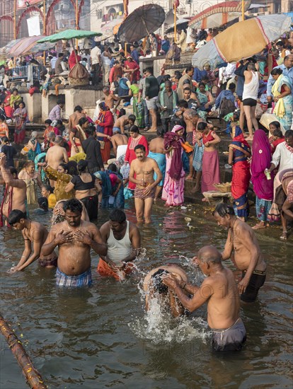 Hindu worshippers perform ritual bath and puja prayers at ghats in the River Ganges