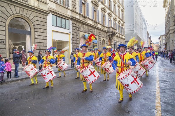 Drummer in historical costume marching through street