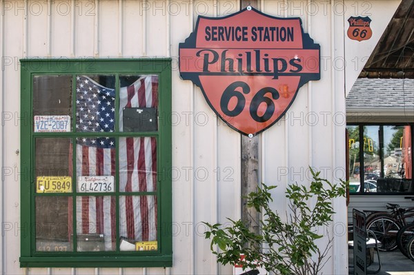Window with American flag at historic gas station Shea's Gas Station