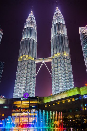 Lighted Petronas Towers with colored fountain at night