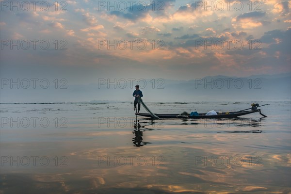 Local Intha fisherman rowing boat with one leg