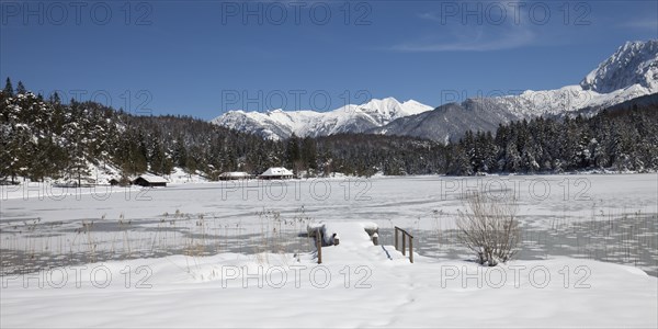Frozen lake Lautersee in front of Karwendel Mountains