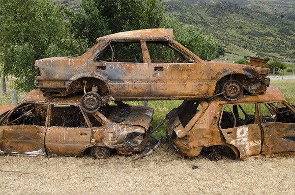 Stack of three rusty car wrecks