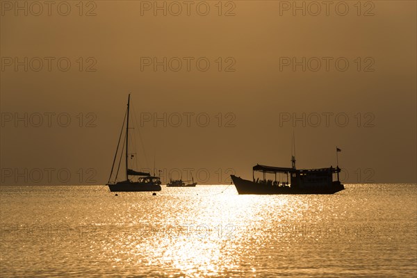 Two boats in sea at sunset