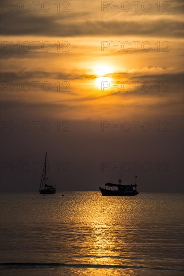 Two boats in sea at sunset