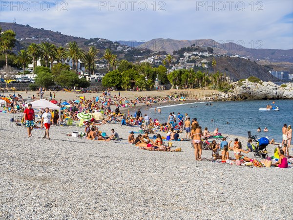 Bathers on the pebble beach of La Herradura