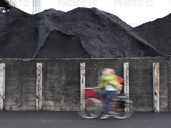 Cyclist riding past coal ash heap