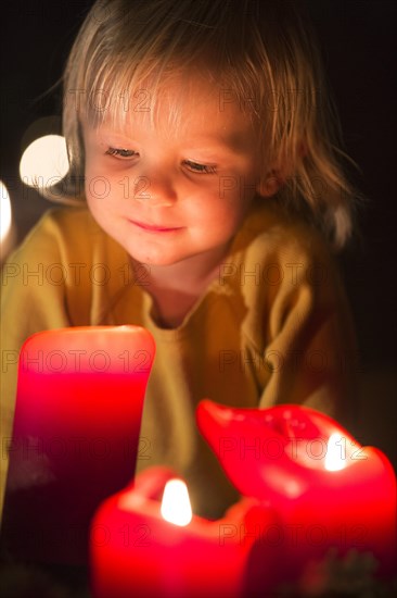 Toddler looking at advent candles at Christmas time