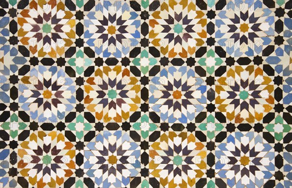 Detail of colourful geometric zellige tileworks in the central courtyard of the Ben Youssef Madrasa