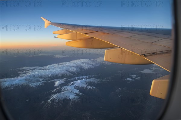 Wing of an Airbus A380-800 over snowy mountains