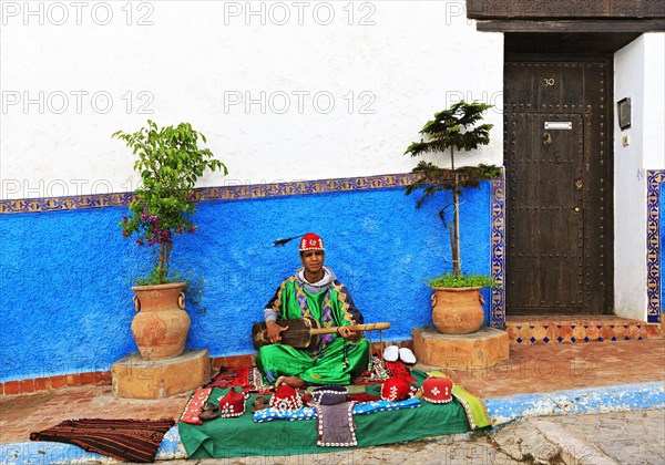 Gnawa musician playing on a Sintir