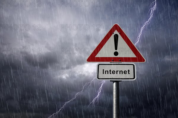 Warning and Internet road signs againt a rainy sky with lightning