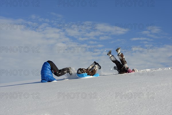 Father and his children rollicking in the snow