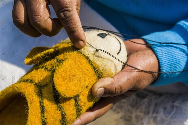 Hands of a woman working on felt shoes