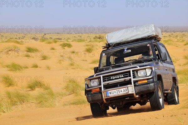 SUV with roof tent on the road in the desert